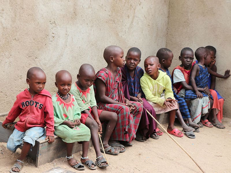 A group of children sitting on the ground.