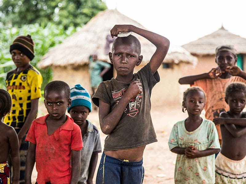 A group of children standing in front of some houses.
