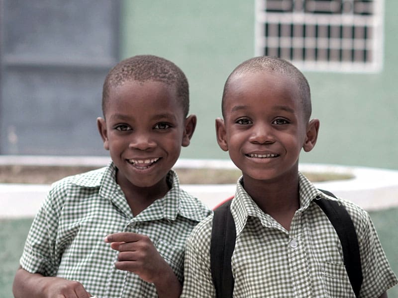 Two young boys are smiling for the camera.