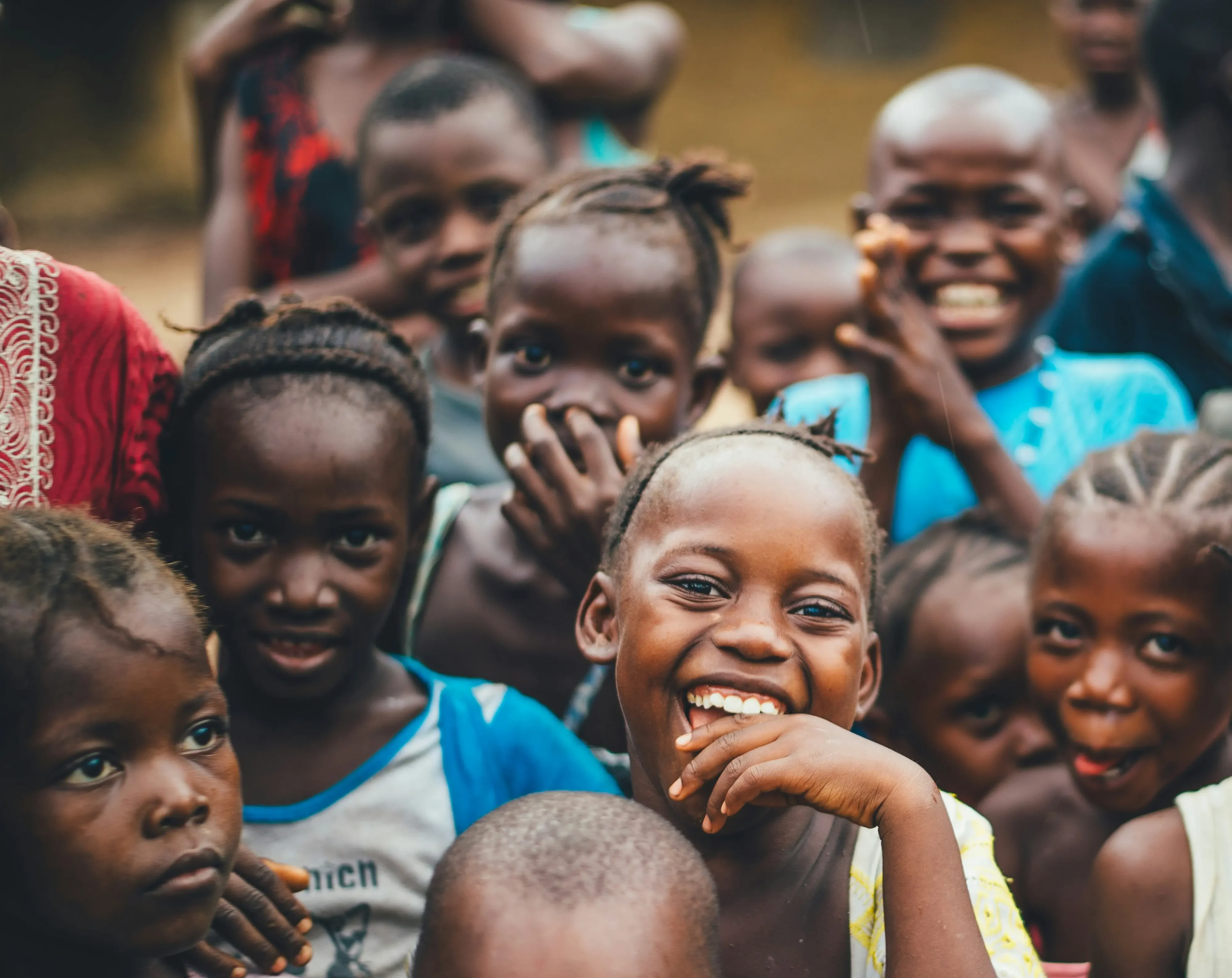 A group of children standing together smiling for the camera.