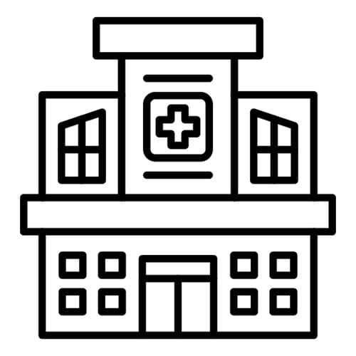 A hospital building with a cross on the top of it.