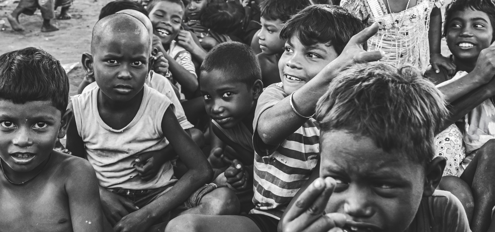 A group of children sitting in the middle of a room.